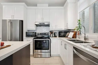 a kitchen with white cabinets and stainless steel appliances at North City Haven - Cozy 2 Bedroom Retreat in Barrie