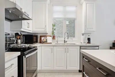 a white kitchen with white cabinets and a sink at North City Haven - Cozy 2 Bedroom Retreat in Barrie