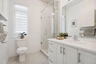 a white bathroom with a toilet and a shower at North City Haven - Cozy 2 Bedroom Retreat in Barrie