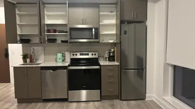 a kitchen with stainless steel appliances and gray cabinets at Trafalgar in Oakville