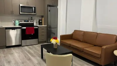 a living room with a couch and a kitchen at Trafalgar in Oakville