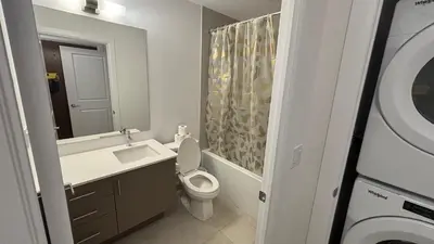 a bathroom with a toilet and a sink and a mirror at Trafalgar in Oakville
