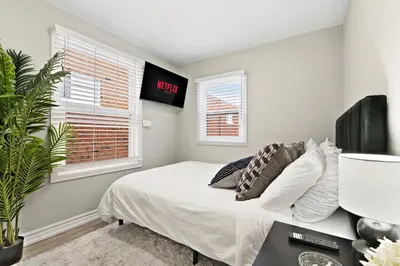 a bedroom with a bed and a clock on the wall at 6BR Family Friendly Retreat, Separate Floors, 5 Minutes Walk to The Fallsview with Free Parking & Wine in Niagara Falls
