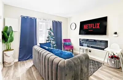 a living room with a couch and a tv at 6BR Family Friendly Retreat, Separate Floors, 5 Minutes Walk to The Fallsview with Free Parking & Wine in Niagara Falls