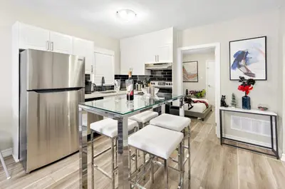 a kitchen with a glass table and stainless steel refrigerator at 6BR Family Friendly Retreat, Separate Floors, 5 Minutes Walk to The Fallsview with Free Parking & Wine in Niagara Falls