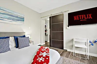 a bedroom with a bed and a television on the wall at 6BR Family Friendly Retreat, Separate Floors, 5 Minutes Walk to The Fallsview with Free Parking & Wine in Niagara Falls