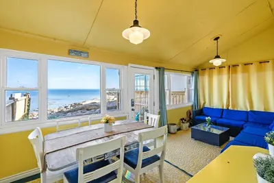 a dining room with a table and a view of the ocean at Crystal Beach Stunning Waterfront Stay with Fire Pit in Fort Erie