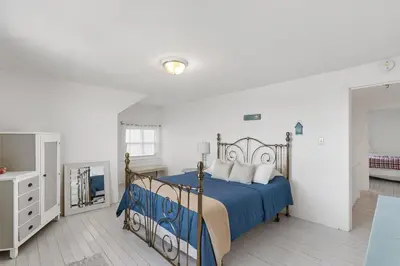 a bedroom with a bed with a blue comforter at Crystal Beach Stunning Waterfront Stay with Fire Pit in Fort Erie