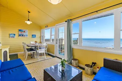 a living room with a view of the ocean at Crystal Beach Stunning Waterfront Stay with Fire Pit in Fort Erie
