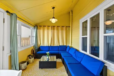 a blue couch in a room with windows at Crystal Beach Stunning Waterfront Stay with Fire Pit in Fort Erie