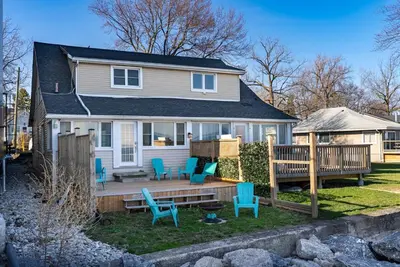 a house with a deck with chairs and a gazebo at Crystal Beach Stunning Waterfront Stay with Fire Pit in Fort Erie