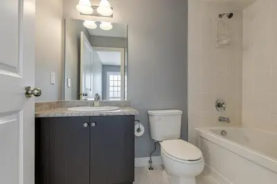 a bathroom with a toilet and a sink and a tub at Cozy 3 Bed Whole Rental Home for your stay! in Brampton