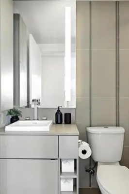 a white bathroom with a sink and a toilet at Luxury Downtown Stay with Spacious Patio in Toronto