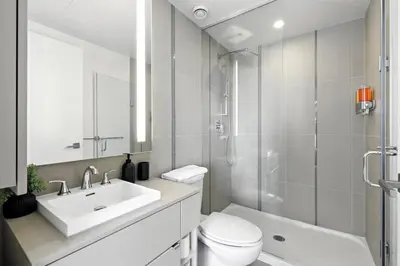 a bathroom with a sink and a toilet and a shower at Luxury Downtown Stay with Spacious Patio in Toronto