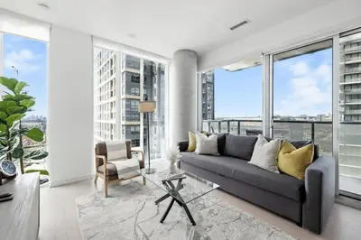a living room with a couch and large windows at Luxury Downtown Stay with Spacious Patio in Toronto