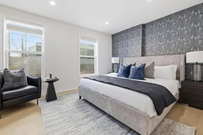 a bedroom with a large bed and a chair at Modern Queen West Retreat Massive Patio 65 TV in Toronto