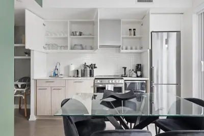 a kitchen with a glass table with chairs in it at Modern Downtown Retreat 3BR Condo with Patio in Toronto