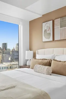 a bedroom with a large white bed with a window at Modern Downtown Retreat 3BR Condo with Patio in Toronto