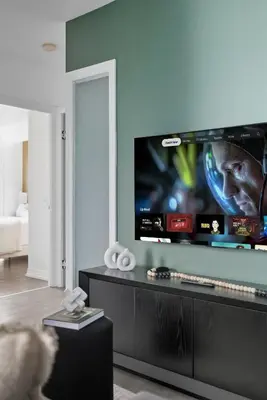 a living room with a flat screen tv on a wall at Modern Downtown Retreat 3BR Condo with Patio in Toronto