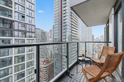 two chairs on a balcony with a view of a city at Modern Downtown Retreat 3BR Condo with Patio in Toronto