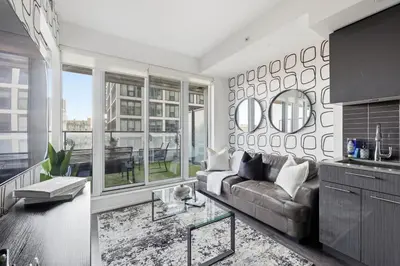 a living room with a couch and a large window at Bright Downtown Condo with City Views & Comfort in Toronto