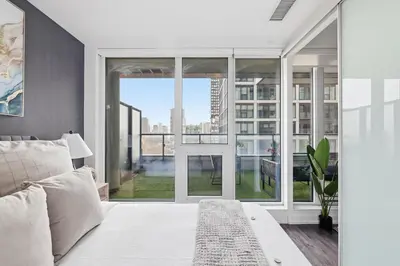 a bedroom with a bed and a large window at Bright Downtown Condo with City Views & Comfort in Toronto