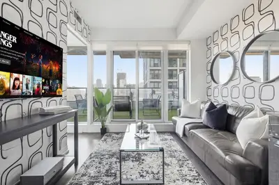 a living room with a couch and a tv at Bright Downtown Condo with City Views & Comfort in Toronto