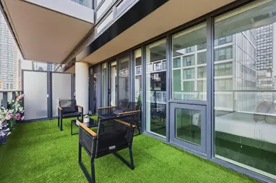 a balcony with two chairs and green grass at Bright Downtown Condo with City Views & Comfort in Toronto