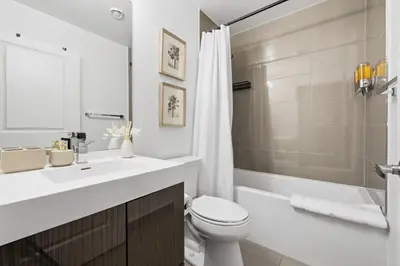 a bathroom with a sink and a toilet and a shower at Bright Downtown Condo with City Views & Comfort in Toronto