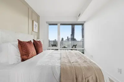 a white bedroom with a large bed and a window at Cozy 1BR Suite Steps to Subway City Views in Toronto