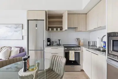 a small kitchen with a glass table and chairs at Cozy 1BR Suite Steps to Subway City Views in Toronto