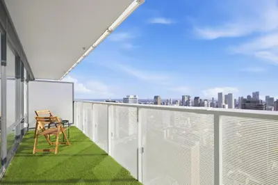 a balcony with a chair and a view of the city at Cozy 1BR Suite Steps to Subway City Views in Toronto