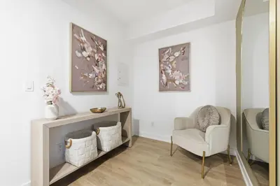 a living room with a chair and a mirror at Cozy 1BR Suite Steps to Subway City Views in Toronto
