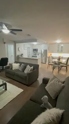 a living room with two couches and a kitchen at Luxurious Two Bedroom Apartment in Burlington