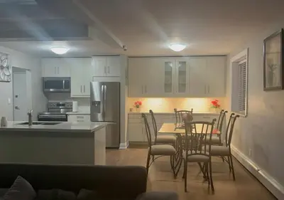 a kitchen and dining room with a table and chairs at Luxurious Two Bedroom Apartment in Burlington