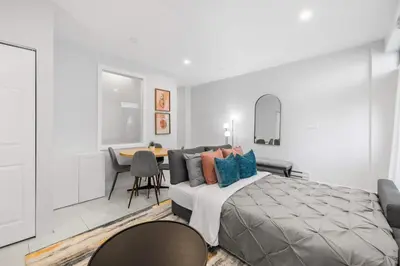 a bedroom with a bed and a table with chairs at Stylish 2BR Retreat by Queen West in Toronto
