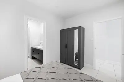 a white room with a bed and a mirror at Stylish 2BR Retreat by Queen West in Toronto