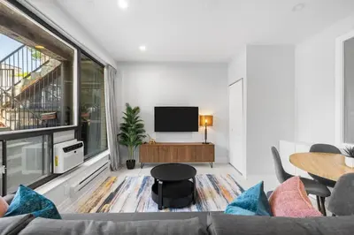 a living room with a couch and a tv at Stylish 2BR Retreat by Queen West in Toronto