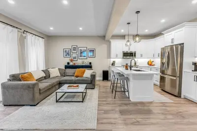 a living room with a couch and a kitchen at Cozy & Modern Home | EV Charger in Elmira
