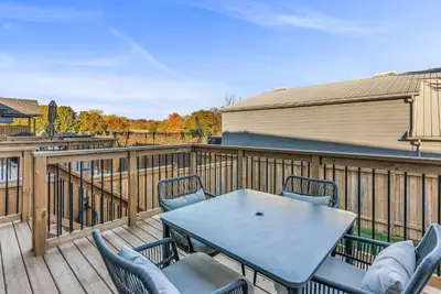 a patio with a table and chairs on a deck at Cozy & Modern Home | EV Charger in Elmira