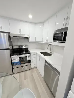 a kitchen with white cabinets and stainless steel appliances at Modern and Cozy Basement Suite,2 Bedrooms with Kitchen ,Parking and Separate Entrance in Milton