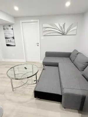a living room with a couch and a glass table at Modern and Cozy Basement Suite,2 Bedrooms with Kitchen ,Parking and Separate Entrance in Milton