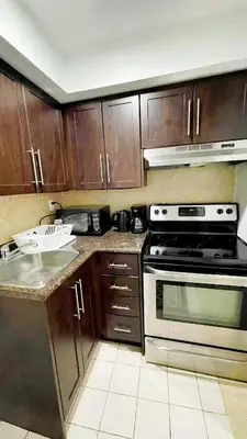 a kitchen with wooden cabinets and a stove at warm heart toronto in Toronto