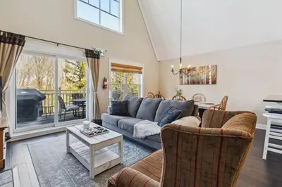 a living room with a couch and a table at 225 Snowbridge with Village Shuttle in Blue Mountains