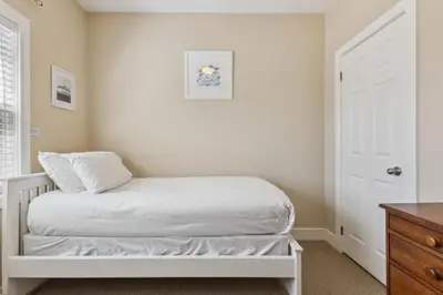 a bedroom with a white bed and a white door at 225 Snowbridge with Village Shuttle in Blue Mountains