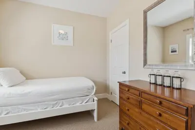 a bedroom with a bed and a dresser with a mirror at 225 Snowbridge with Village Shuttle in Blue Mountains