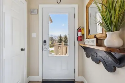 a hallway with a white door and a mirror at 225 Snowbridge with Village Shuttle in Blue Mountains