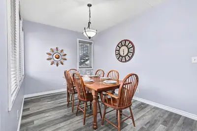 a dining room with a table and chairs and a clock at 2BDR Condo Steps to Blue Mountain Village - 101 Cachet Crossing in Blue Mountains