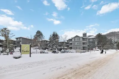 a street covered in snow with buildings in the background at 2BDR Condo Steps to Blue Mountain Village - 101 Cachet Crossing in Blue Mountains