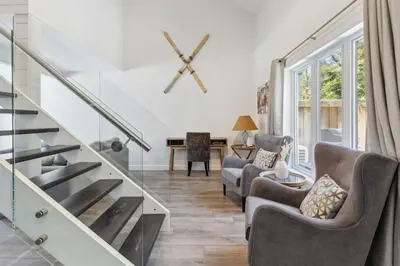 a living room with two chairs and a staircase at Townhouse with Hot Tub near Blue Mountain Village - 162 Vacation Inn in Collingwood